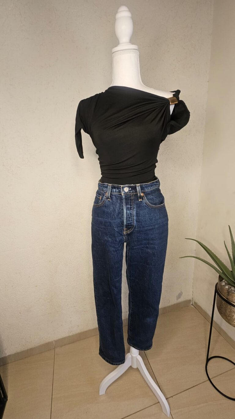 One-shoulder draped top with gold embellishments.